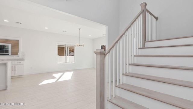 stairs featuring a chandelier