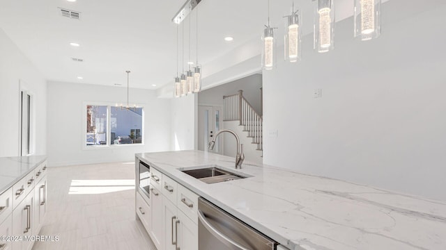 kitchen featuring light stone countertops, sink, hanging light fixtures, stainless steel appliances, and white cabinets