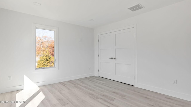 unfurnished bedroom featuring a closet and light hardwood / wood-style flooring