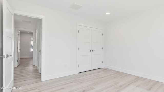 unfurnished bedroom featuring a closet and light hardwood / wood-style floors