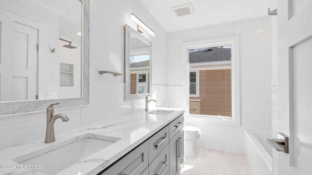 bathroom with vanity, tile patterned floors, toilet, tile walls, and walk in shower