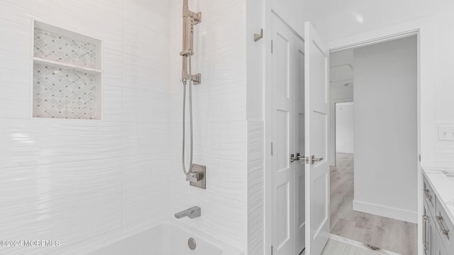 bathroom with bathing tub / shower combination, vanity, and wood-type flooring