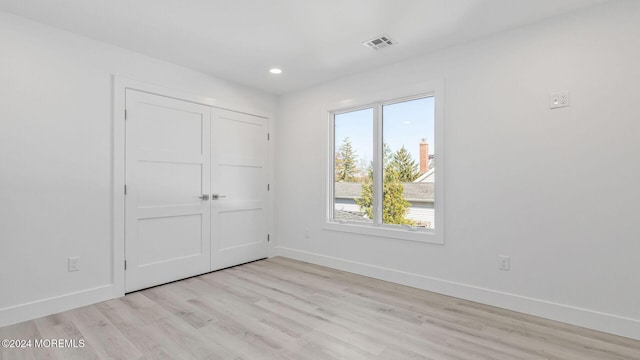 unfurnished bedroom featuring light wood-type flooring and a closet