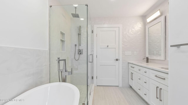 bathroom with vanity, shower with separate bathtub, and tile walls