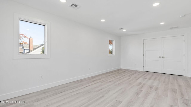 unfurnished bedroom with light hardwood / wood-style flooring and a closet