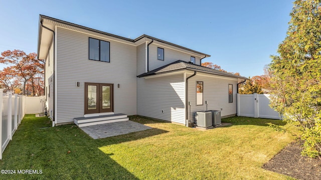 back of house featuring central AC unit, a yard, and french doors