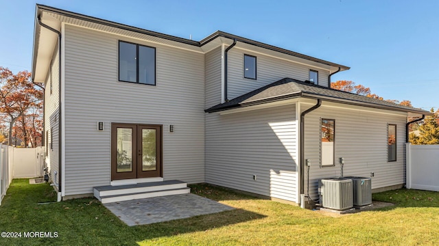 back of house with a lawn and central AC unit