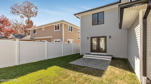 back of property with a lawn and french doors