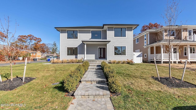 view of front of house featuring a balcony and a front lawn