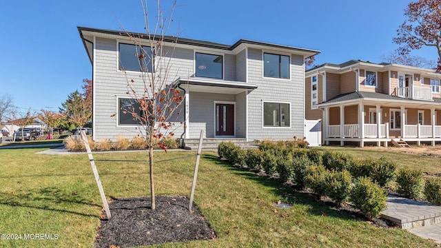 rear view of property with a yard and a balcony