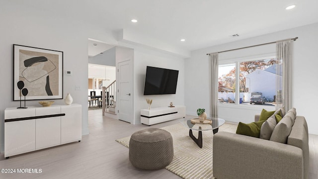 living room with a notable chandelier and light hardwood / wood-style floors