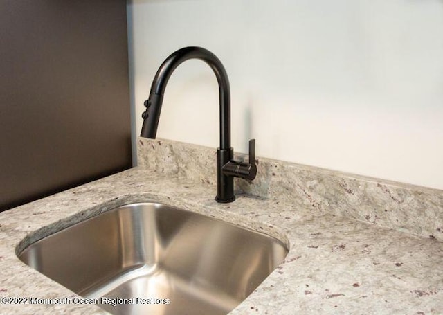 room details featuring light stone counters and sink