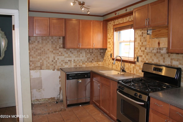 kitchen with sink, tasteful backsplash, appliances with stainless steel finishes, light tile patterned floors, and ornamental molding