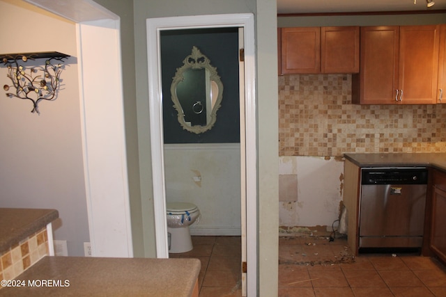 kitchen featuring stainless steel dishwasher, decorative backsplash, and light tile patterned floors