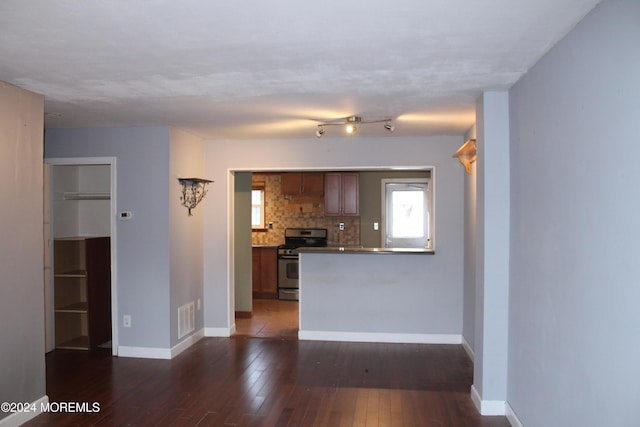 kitchen with gas stove, decorative backsplash, and dark hardwood / wood-style floors