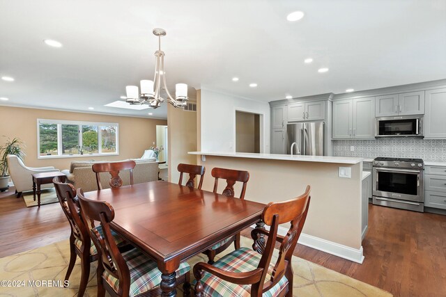 dining area featuring an inviting chandelier and light hardwood / wood-style flooring