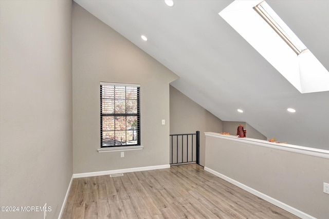 bonus room with light hardwood / wood-style flooring and vaulted ceiling with skylight