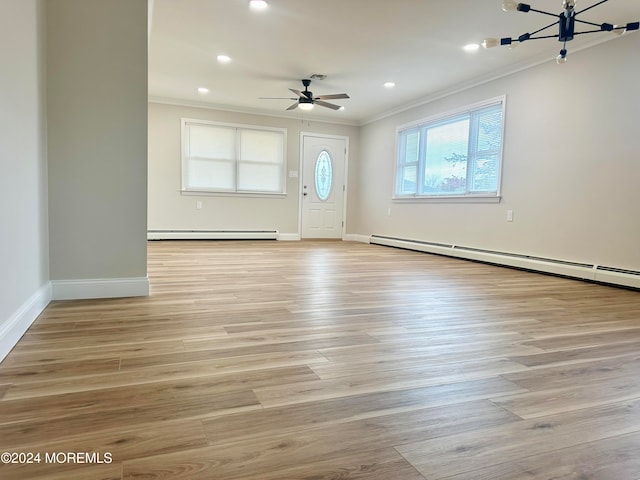 entrance foyer featuring baseboard heating, crown molding, and light hardwood / wood-style floors