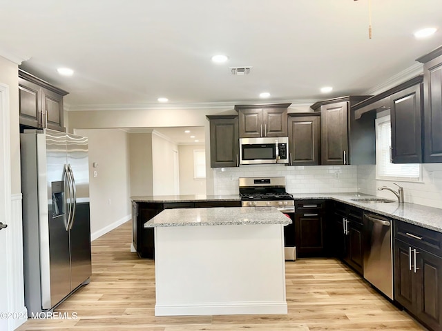 kitchen featuring a center island, sink, light hardwood / wood-style flooring, tasteful backsplash, and stainless steel appliances