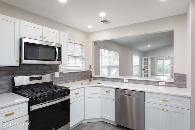 kitchen featuring backsplash, sink, white cabinets, and stainless steel appliances