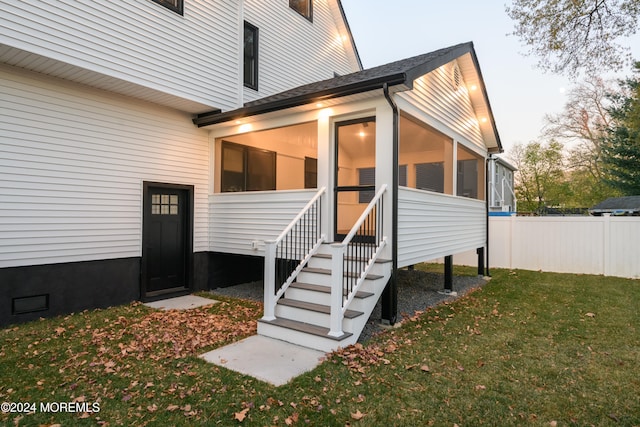 exterior entry at dusk with a lawn