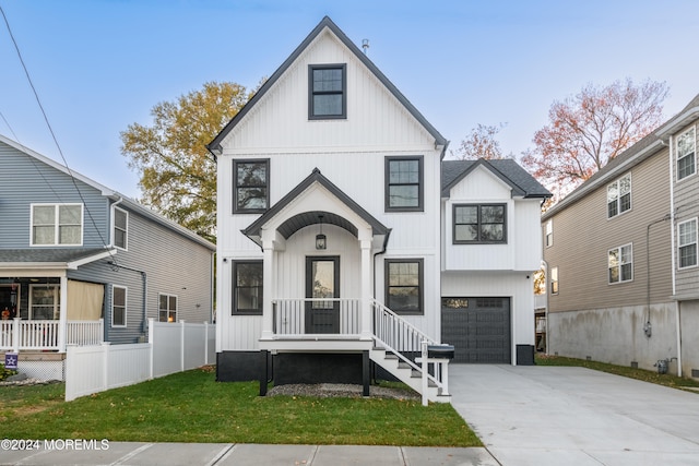 modern farmhouse featuring a front yard and a garage