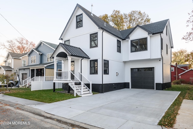 modern farmhouse style home featuring a front yard and a garage