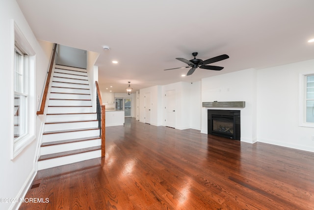 unfurnished living room with dark hardwood / wood-style floors and ceiling fan