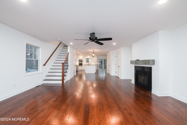 unfurnished living room featuring ceiling fan and dark wood-type flooring