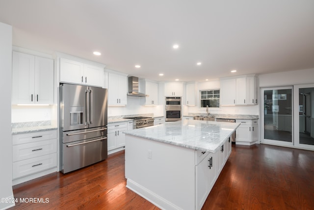 kitchen featuring white cabinets, a center island, high quality appliances, and wall chimney range hood