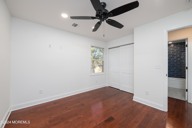 unfurnished bedroom featuring ceiling fan, dark wood-type flooring, and a closet