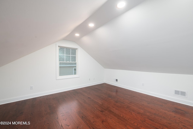 bonus room with dark hardwood / wood-style floors and vaulted ceiling