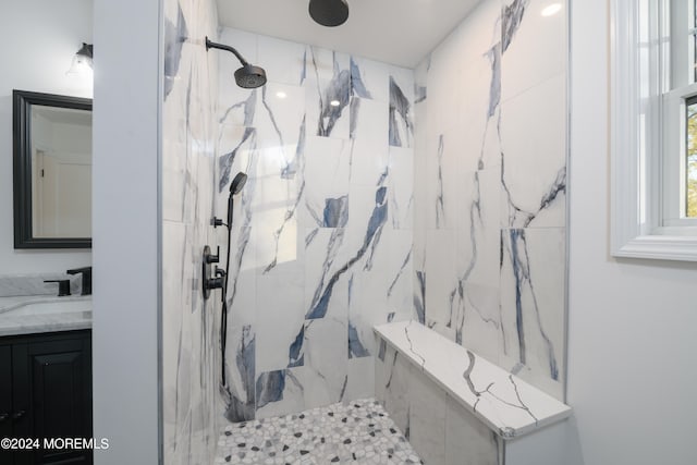 bathroom featuring a tile shower and vanity