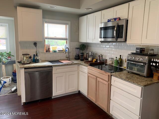 kitchen featuring white cabinetry, stainless steel appliances, and a wealth of natural light