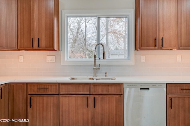 kitchen featuring dishwasher, decorative backsplash, and sink