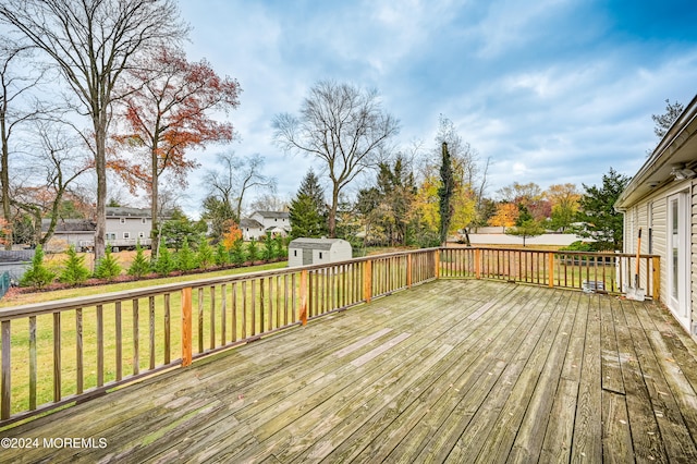 deck with a lawn and a storage shed