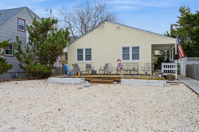 rear view of house featuring a wooden deck