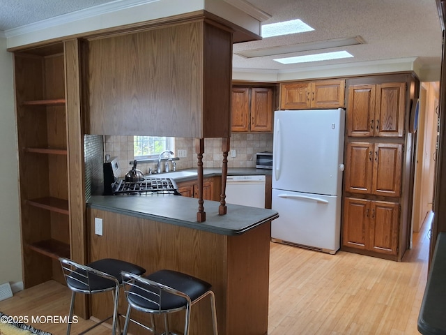 32 Village Rd, Morganville, NJ 07751 - kitchen with dark countertops, a sink, white appliances, a peninsula, and a textured ceiling