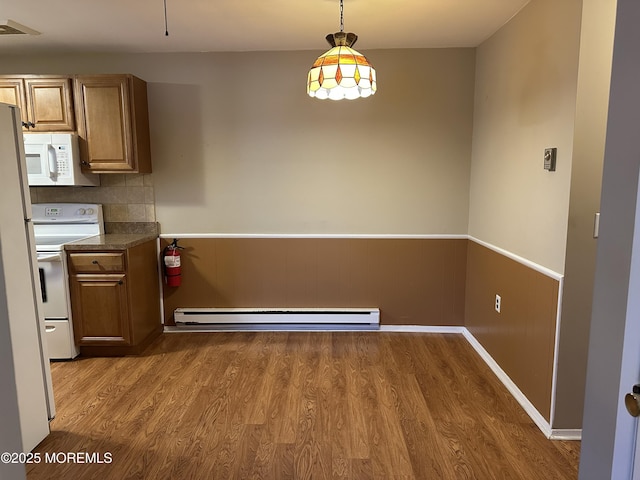 kitchen with decorative backsplash, white appliances, wood-type flooring, a baseboard radiator, and hanging light fixtures