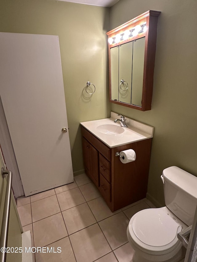 bathroom with tile patterned flooring, vanity, and toilet