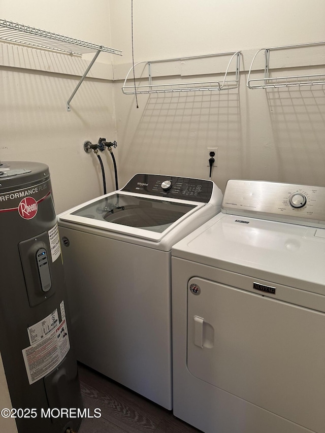 laundry room featuring washing machine and dryer, water heater, and dark hardwood / wood-style floors