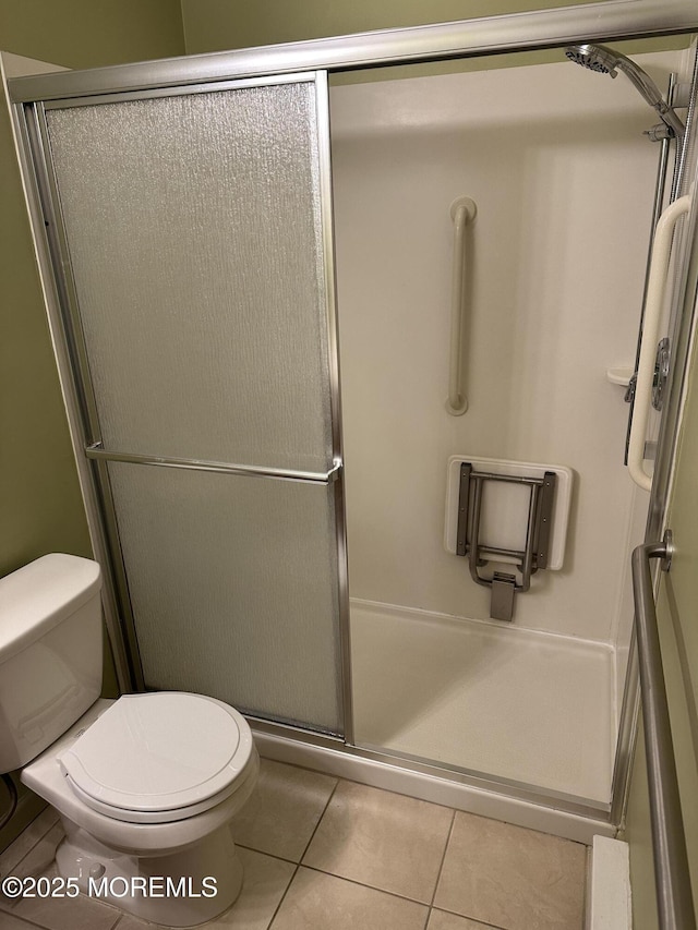 bathroom with toilet, tile patterned flooring, and walk in shower