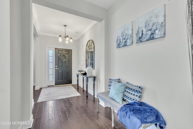 foyer featuring ornamental molding, an inviting chandelier, dark wood finished floors, and baseboards