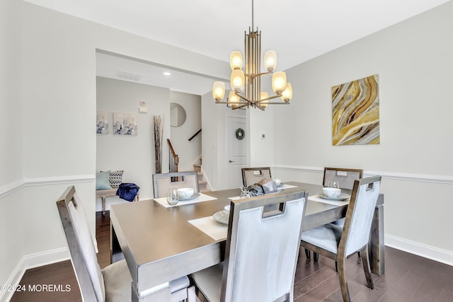 dining space with visible vents, baseboards, wood finished floors, an inviting chandelier, and stairs