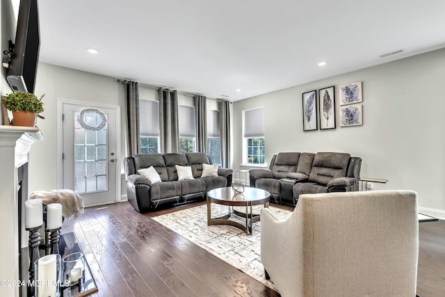 living room with a fireplace, visible vents, dark wood finished floors, and recessed lighting