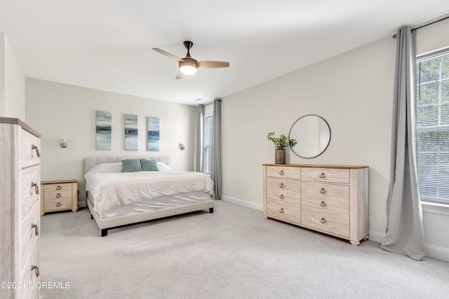 bedroom featuring baseboards, a ceiling fan, and light colored carpet