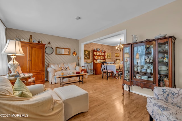 living room with light hardwood / wood-style floors and an inviting chandelier