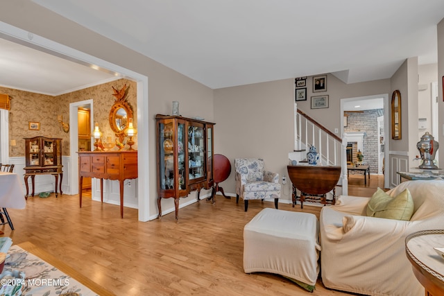 living room featuring crown molding and light hardwood / wood-style flooring