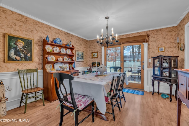 dining area featuring light hardwood / wood-style flooring, a notable chandelier, and crown molding