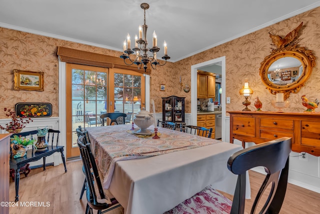 dining room featuring light wood-type flooring, an inviting chandelier, and crown molding